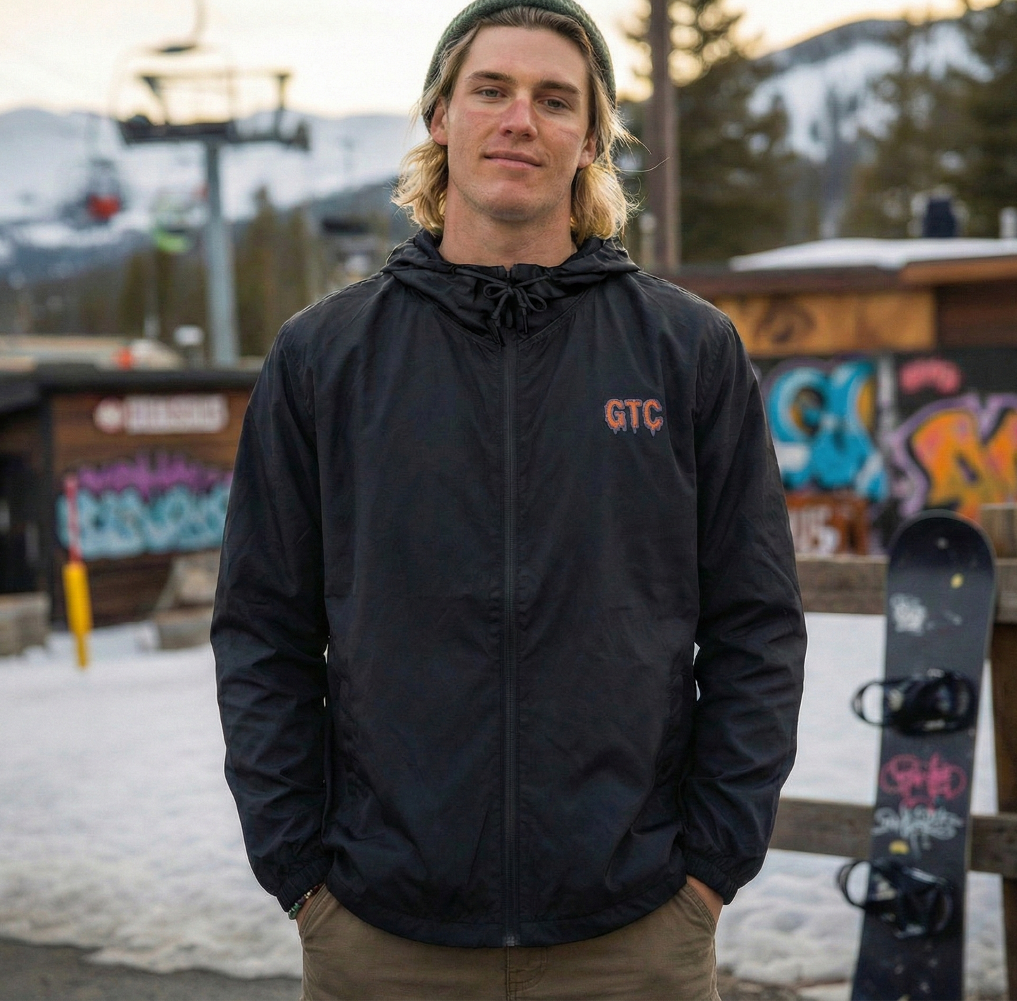Person wearing a black jacket with 'GTC' logo in a snowy outdoor setting
